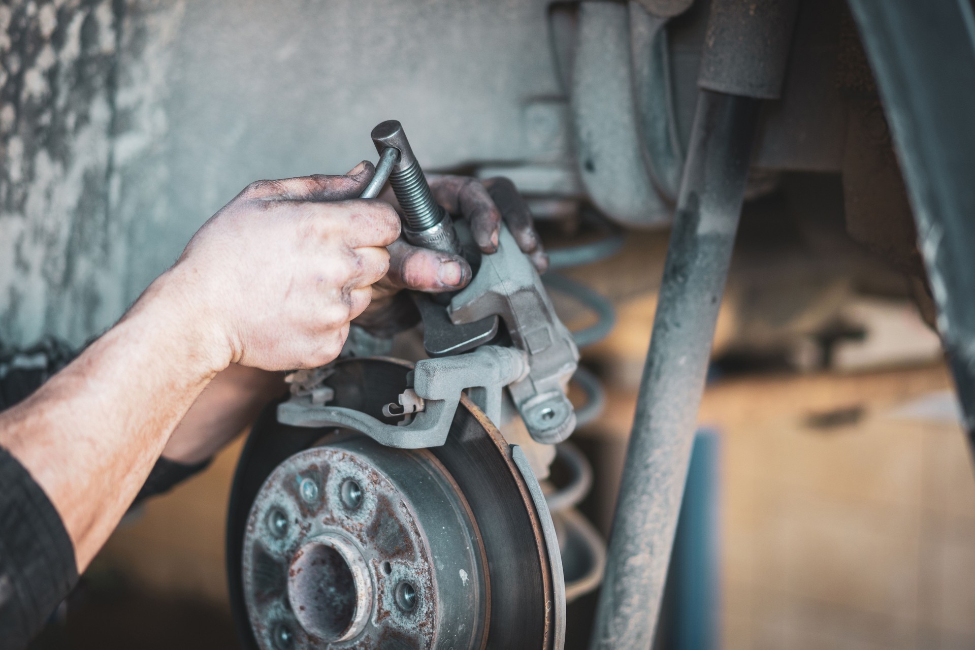 Man hand Brake pad replacement in car service