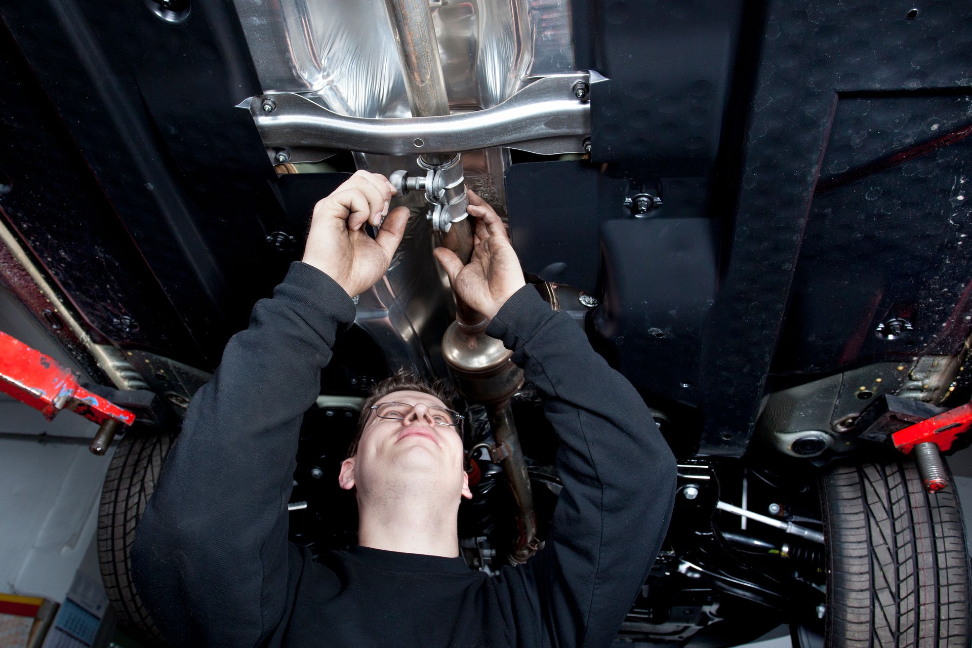 Mechanic is fixing the exhaust system